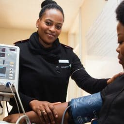 A female Nurse checking a woman's blood pressure