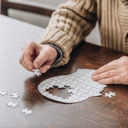 cropped view of senior man playing with puzzles