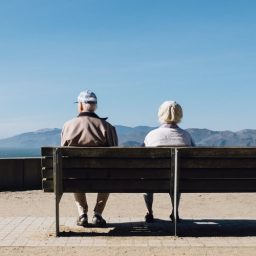 Two seniors sit on bench