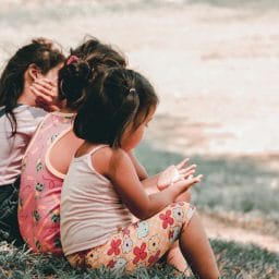 Children sit together outside.