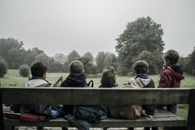 Several children socializing on a bench.