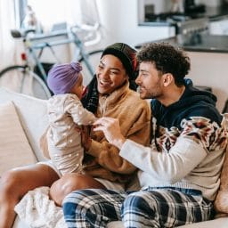 Happy young family playing with their baby.