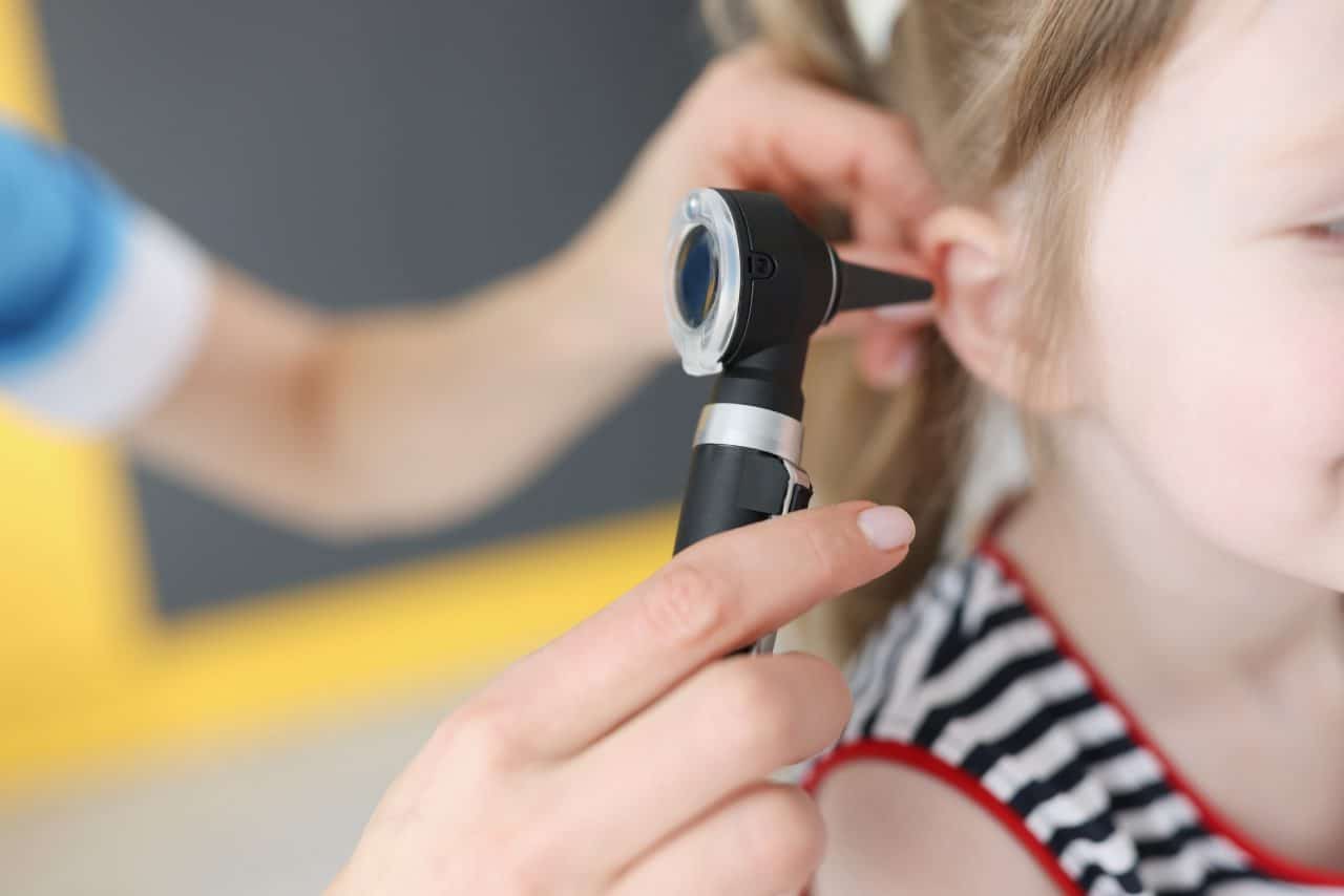 Doctor examines ear drum of little girl. Hearing impairment in children concept
