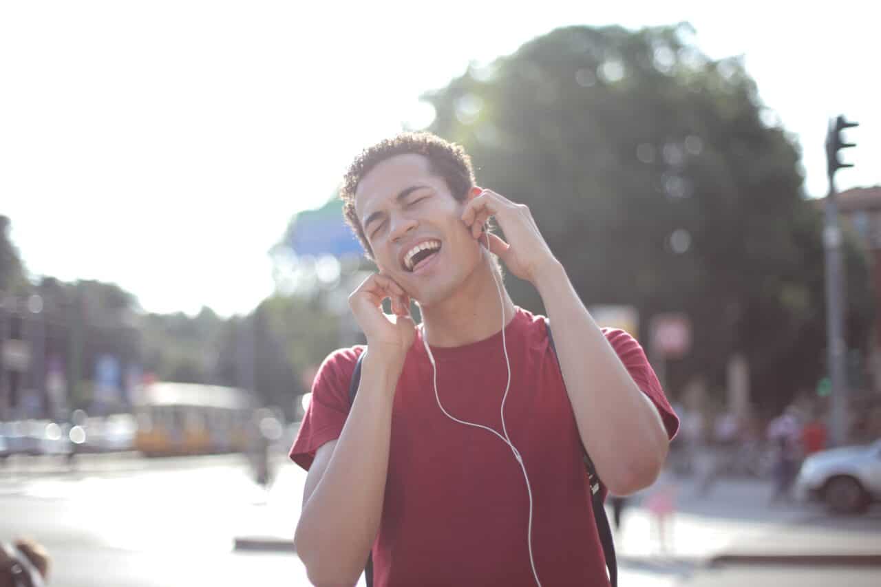 Young man listening to music on earbuds loudly.
