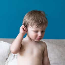 Child holds ear, appears in pain