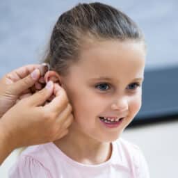 Young girl getting her first hearing aid