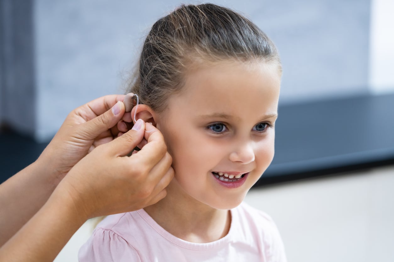Young girl getting her first hearing aid.
