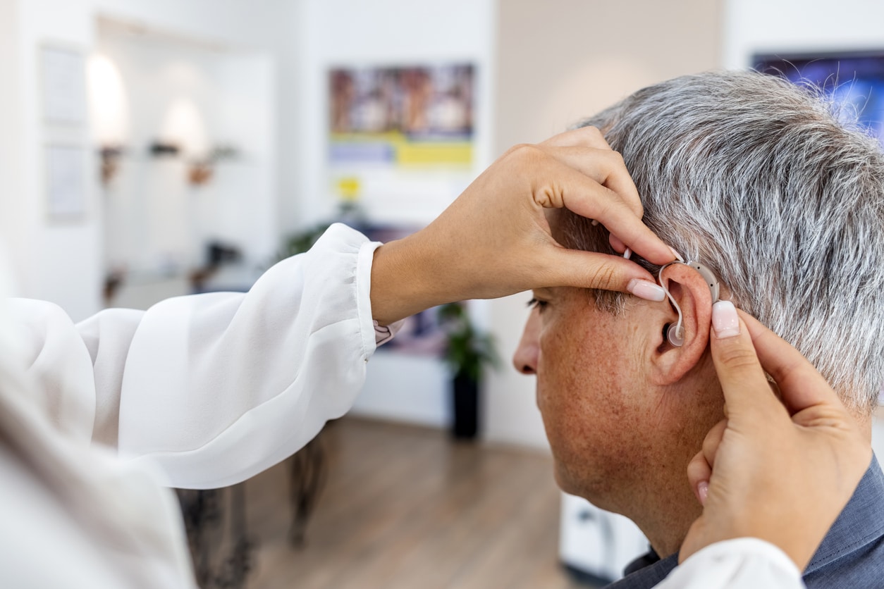 Senior man getting a new hearing aid.